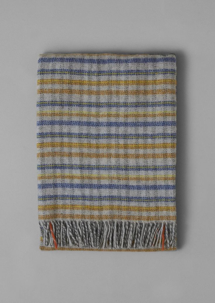 a multicolored plaid blanket with fringes