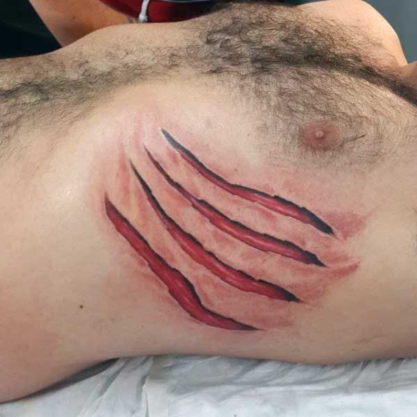 a man laying on top of a bed covered in red ink with his arm extended