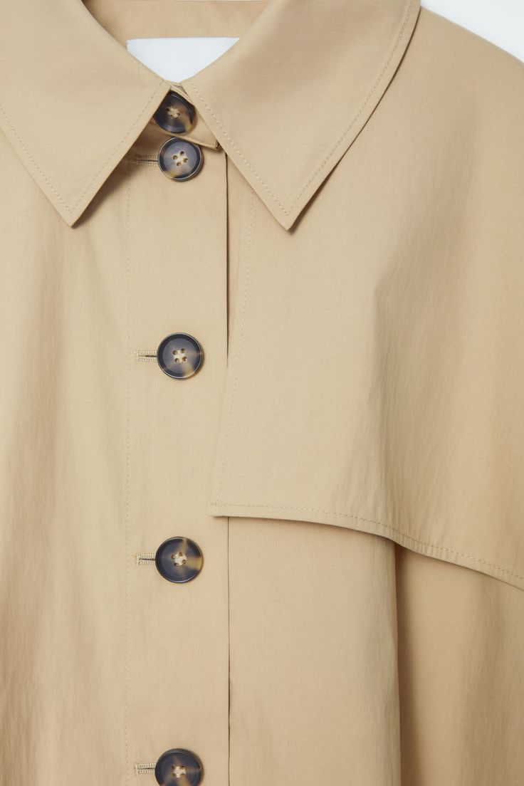 CROPPED TRENCH COAT CAPE - LIGHT BEIGE - COS Workwear Cape With Button Closure, Workwear Cape Outerwear With Button Closure, Oversized Beige Cape Outerwear, Cape-style Buttoned Outerwear For Work, Modern Workwear Cape Outerwear, Modern Cape-style Workwear Outerwear, Modern Cape For Workwear, Modern Cape Outerwear For Work, Spring Workwear Cape