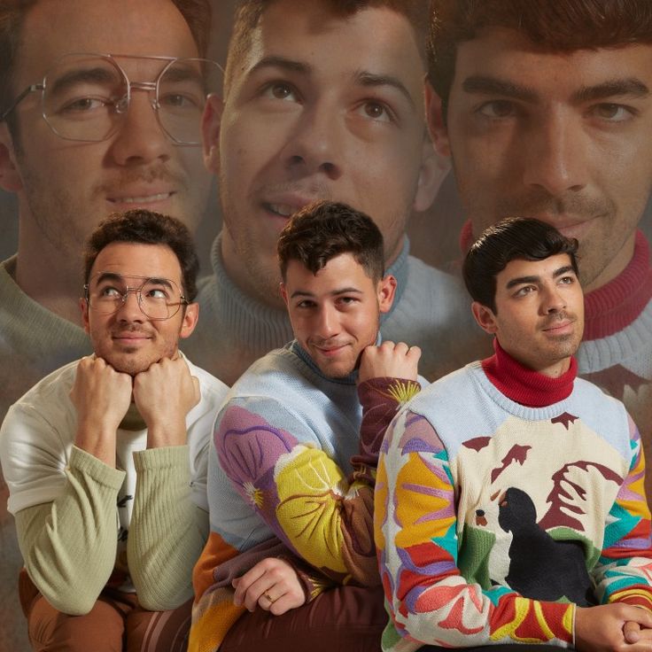 three men are posing for the camera with their hands on their chins in front of them