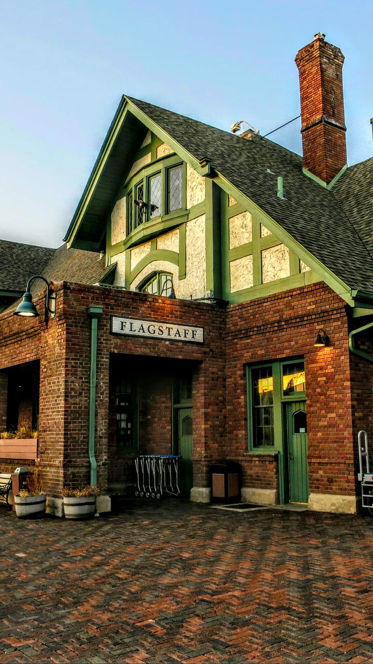 an old brick building with green trim and windows