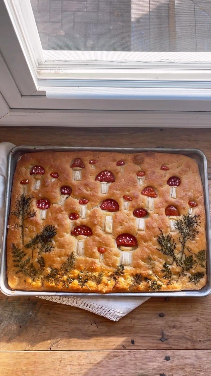 a baking dish with meat and vegetables in it sitting on a table next to a window