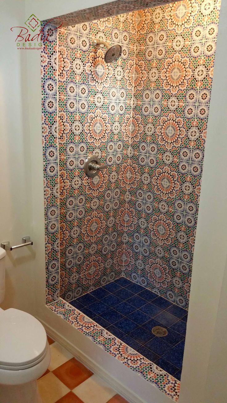 a bathroom with a toilet, shower and tiled flooring in the middle of it