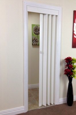 there is a vase with flowers on the floor in front of an open white door