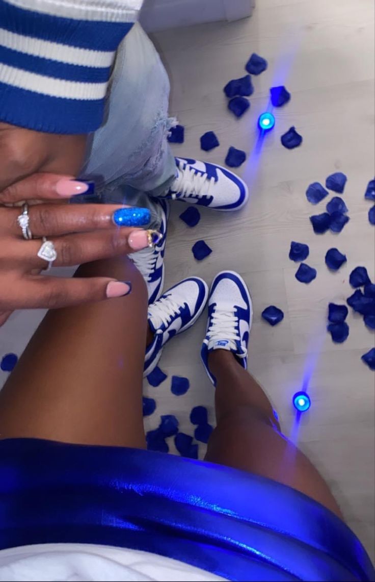 two people with blue and white nail polish on their feet