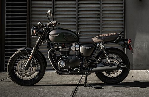 a black motorcycle parked in front of a garage door with shutters on the side