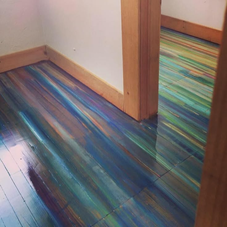 an empty room with wood floors and multicolored flooring on the wooden floor