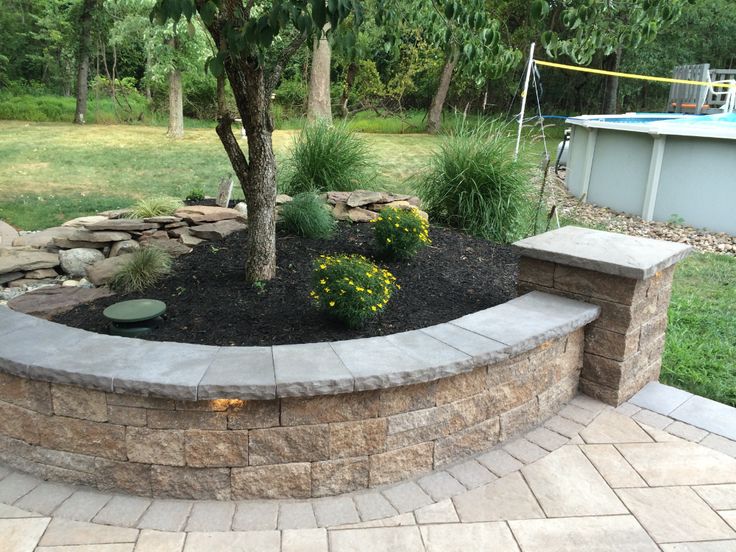 a stone retaining wall around a pool area