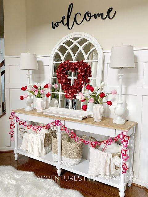 a wooden table topped with lots of baskets filled with flowers next to a welcome sign