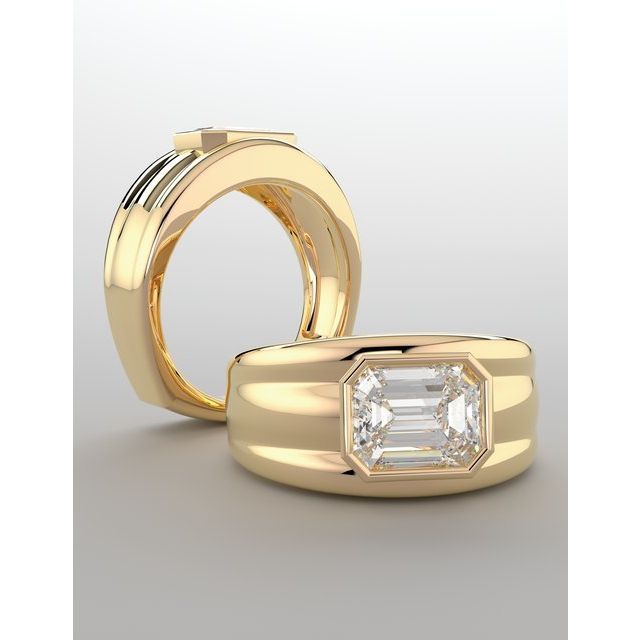 two gold wedding rings with an emerald cut diamond