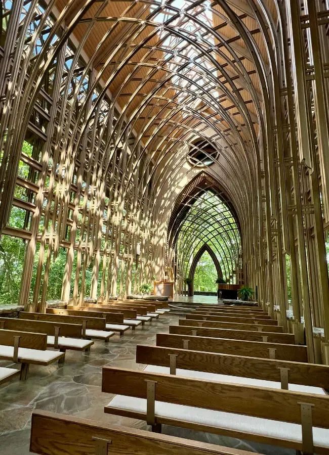 the inside of a church with wooden pews and benches lined up against the wall