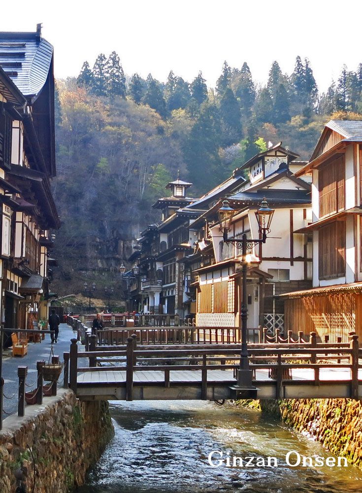 a river running through a village next to tall buildings