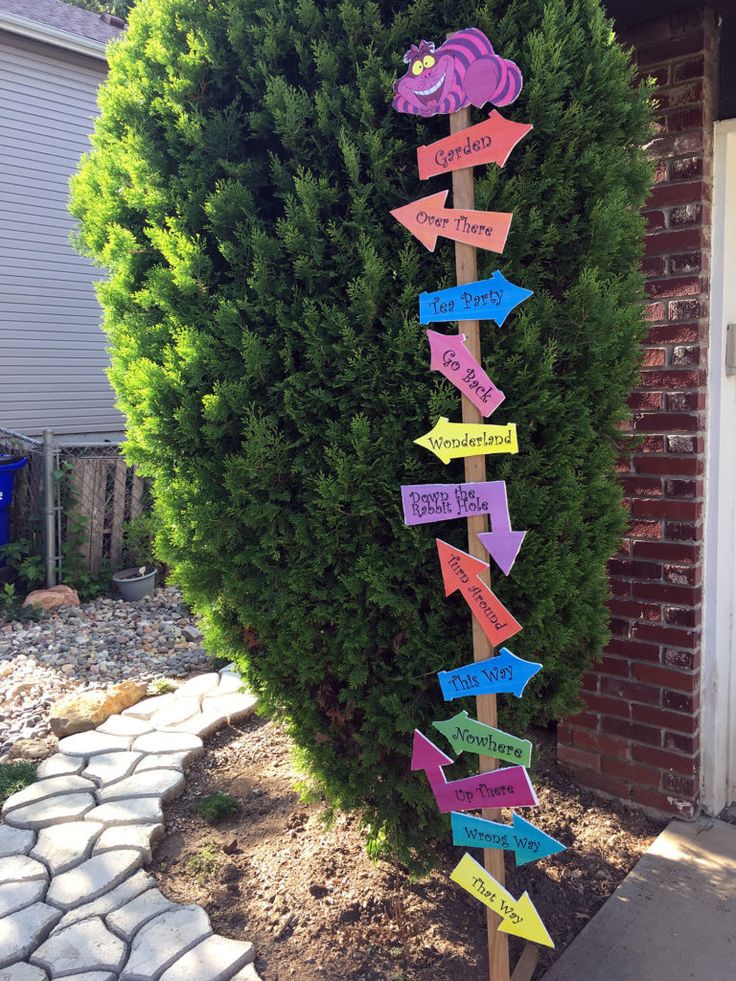 a wooden pole with many different colored signs attached to it's sides in front of a house