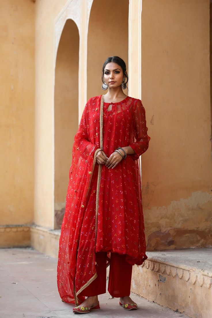 The set consists of georgette a line kurta comes with full length inner, hand work detailing round neck, calf length teamed with cotton palazzo pants and a georgette dupatta to match.The entire set has hand work detailing. Kurta Fabric-Georgette Pant Fabric-Cotton Duptta Fabric-Georgette Color-Red Kurta Length-45 inches Pant Length-37 inches Work-Hand Work Detailing & Bandhej Print Neck-Round Sleeves-Full Sleeves Washing Instructions-Dry Clean Model is 5'6 wearing small size. Floor-length Georgette Palazzo Set For Transitional Seasons, Transitional Floor-length Georgette Palazzo Set, Navratri Georgette Palazzo Set With Cutdana, Georgette Palazzo Set With Cutdana For Navratri, Floor-length Georgette Kurta With Cutdana, Festive Georgette Palazzo Set With Cutdana Details, Navratri Georgette Palazzo Set With Mirror Work, Festive Georgette Palazzo Set With Cutdana, Anarkali Palazzo Set With Traditional Drape In Georgette