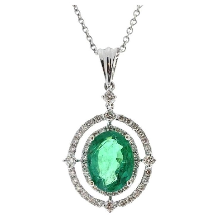 This stunning pendant features a vibrant 2.69-carat green oval emerald, renowned for its deep, lush color and exceptional clarity. The emerald is elegantly encircled by 50 round diamonds, with a total weight of 0.60 carats, which add a brilliant sparkle and enhance the gemstone's rich hue. Set in sophisticated 14k white gold, this pendant creates a beautiful contrast with the emerald’s vivid green tones, making it a timeless and eye-catching piece. Perfect for any special occasion, this pendant Luxury Oval Emerald Necklace In White Gold, Luxury Oval Pendant Emerald Necklace, Oval Emerald Pendant, Emerald Necklace Pendant, Green Oval, Emerald Pendant, Elegant Pendant, Modern Necklaces, Emerald Stone