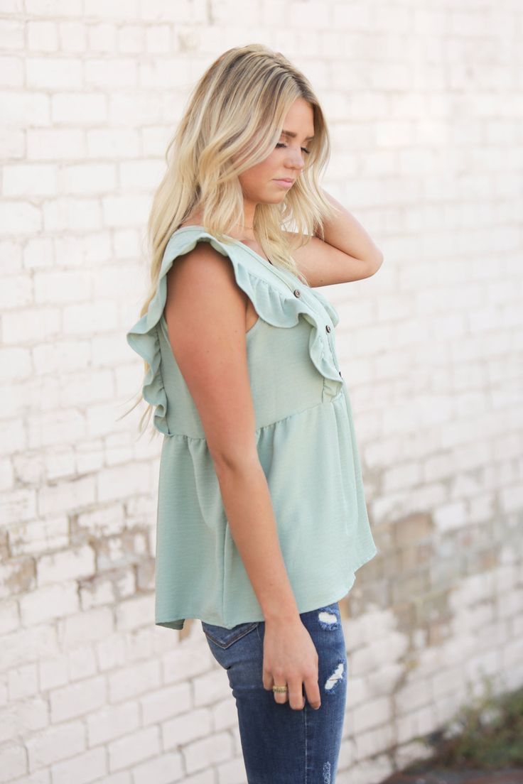 Nothing says "Hi, summer," quite like an airy top. This one's complete with smocked detailing, a v neckline and flutter sleeves. Our Jenna Ruffle Top is perfect with jeans or cut offs. Models are 5'7" and 5'8" wearing a size small Length of a small is 24" 100% Polyester Summer Smocked Top With Ruffles, Summer Smocked Top With Ruffled Straps For Spring, Spring Smocked Top With Ruffled Straps For Day Out, Spring Day Out Smocked Top With Ruffles, Chic Green Smocked Top For Summer, Spring Smocked Top With Ruffles For Day Out, Casual Smocked Top With Ruffled Straps For Summer, Summer Tops With Ruffled Straps For Spring, Summer V-neck Top With Smocked Bodice