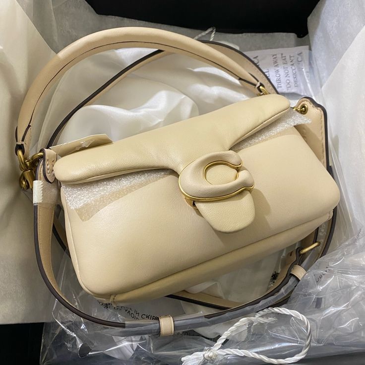 Nappa Leather Inside Multifunction Pocket Snap Closure, Fabric Lining Detachable Handle With 4" Drop Detachable Long Strap With 21 1/2" Drop For Shoulder Or Crossbody Wear 7 1/4" (L) X 4" (H) X 2 1/2" (W) Coach Pillow Tabby Shoulder Bag 18 Ivory From Coach Store Coach Flap Shoulder Bag With Detachable Handle, High-end Cream Shoulder Bag With Detachable Strap, Luxury Cream Coach Shoulder Bag, Designer Coach Flap Bag With Detachable Strap, Luxury Coach Bags With Magnetic Closure, Luxury Coach Shoulder Bag With Magnetic Closure, Coach Top Handle Bag With Magnetic Closure, Coach Pillows, Grey Shoulder Bag