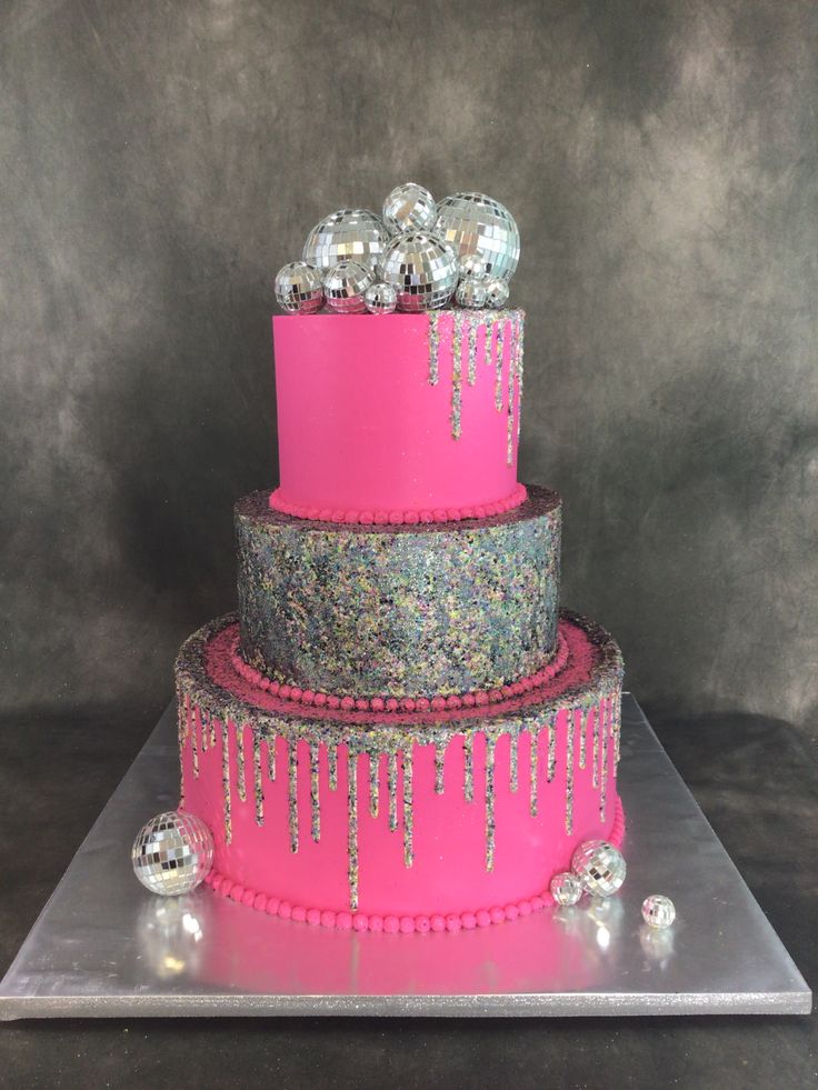 a three tiered cake with pink icing and silver decorations