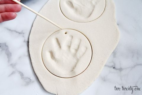 a hand print is being made on top of a cookie sheet with a toothpick