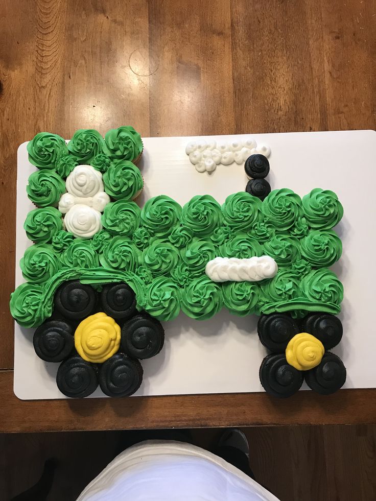 a cake made to look like a tractor with green icing and white flowers on it