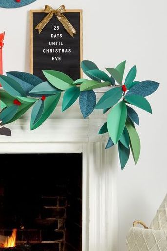 a fireplace decorated for christmas with paper leaves