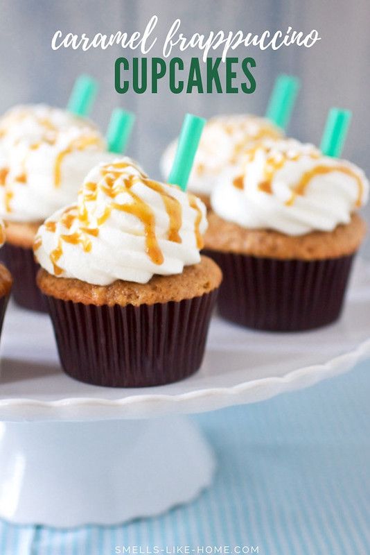 some cupcakes with icing and caramel on top sitting on a cake plate