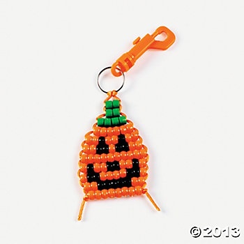 an orange beaded pumpkin ornament hanging from a hook on a white background