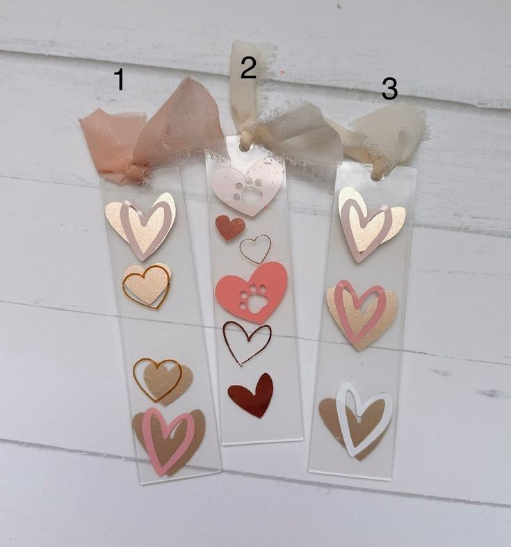 three tags with hearts on them are hanging from a string and tied to a wall