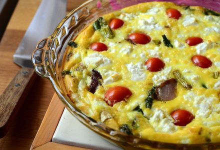 a casserole with tomatoes, cheese and other toppings in a glass dish