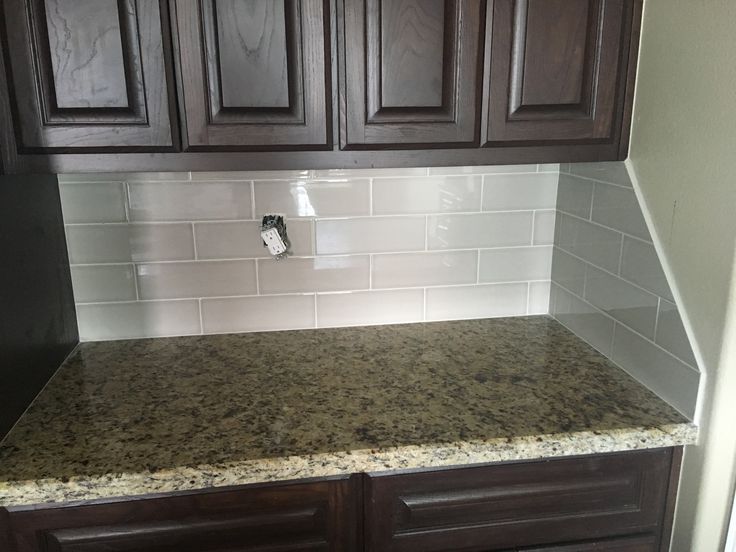 a kitchen counter with brown cabinets and white tile