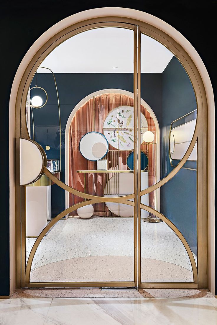 an arched glass door leading into a room with clocks on the wall and marble flooring