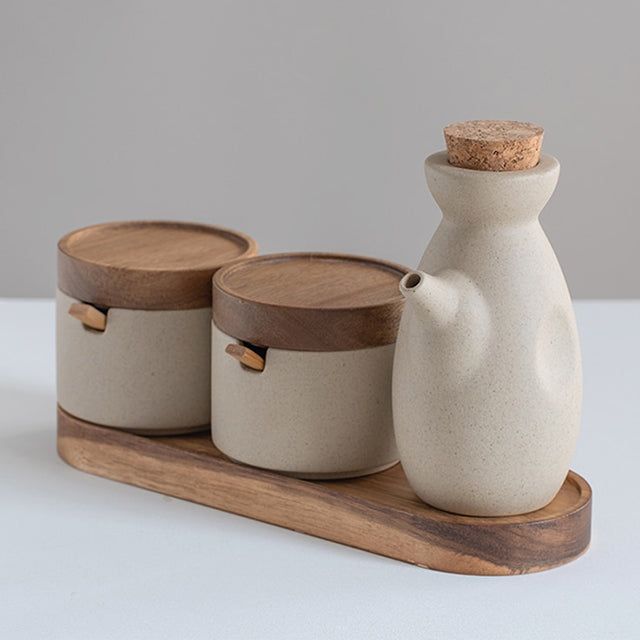 three ceramic containers with wooden lids on a tray