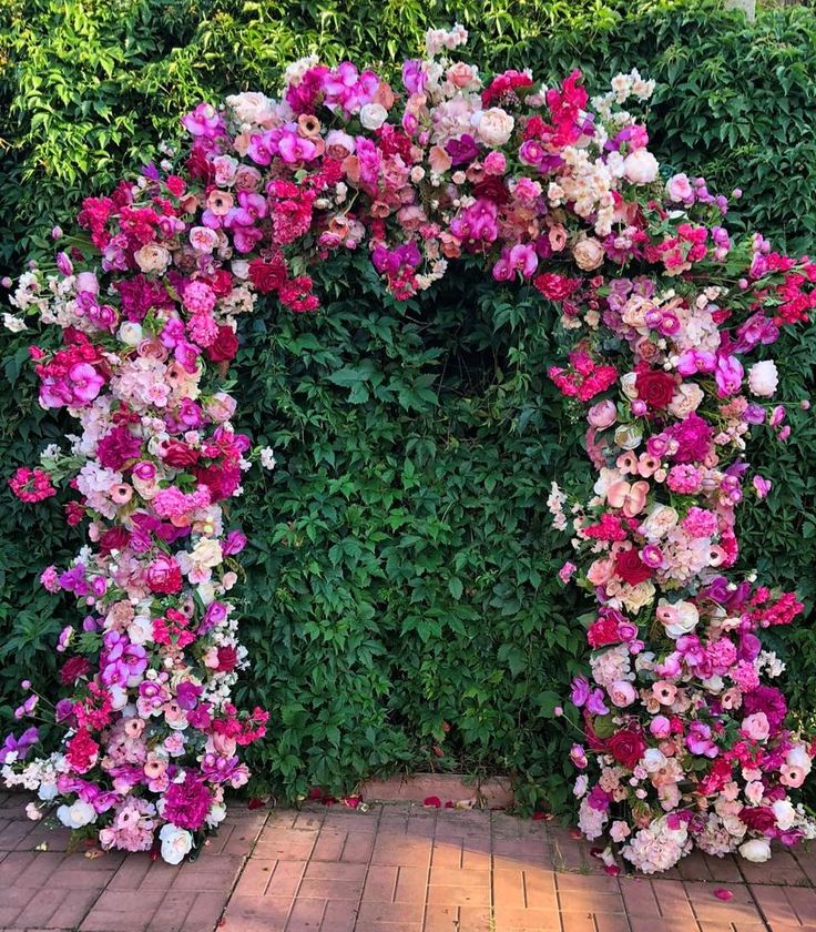 an arch made out of pink and white flowers