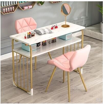 a white table with two pink chairs and a mirror