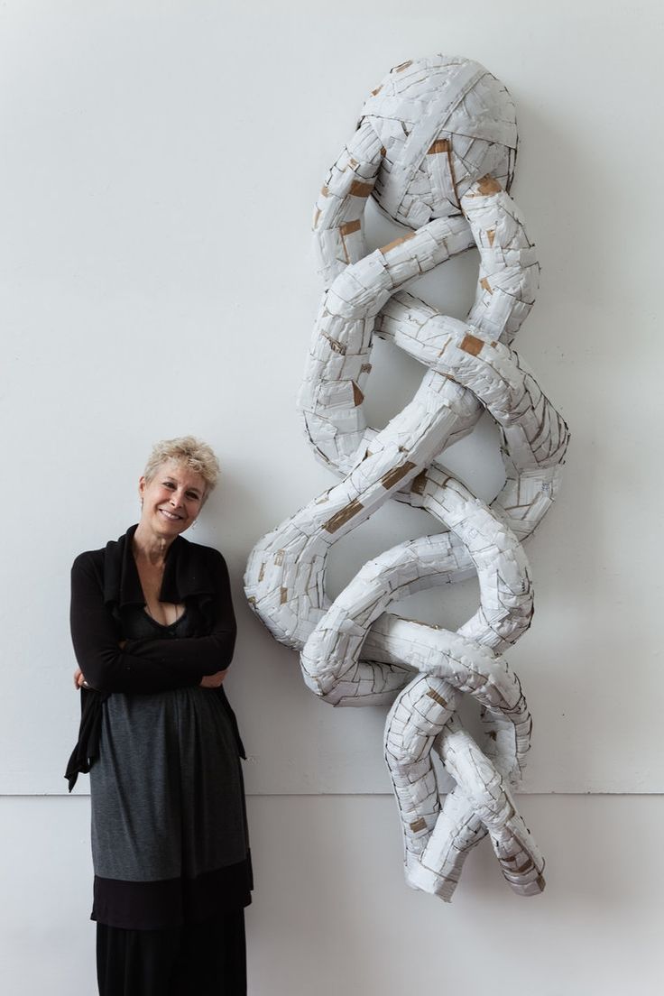 a woman standing next to a large sculpture