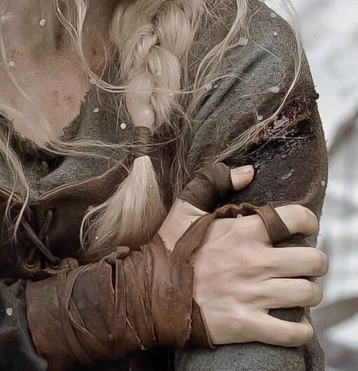 a close up of a person with long hair and braids on her head wearing gloves