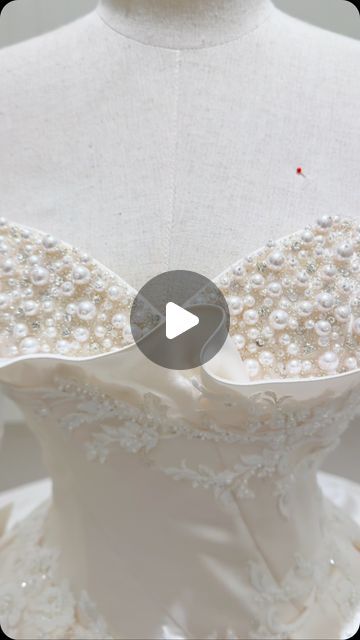 the back of a white dress with pearls on it and a video screen showing how to sew