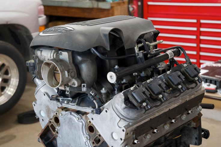 an engine is shown in the garage with other tools on the table and behind it