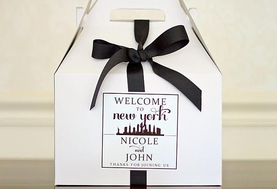 a welcome to new york gift box with a ribbon tied around the front and side