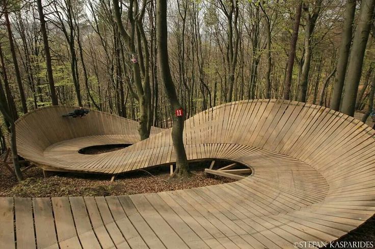 a wooden bench sitting in the middle of a forest