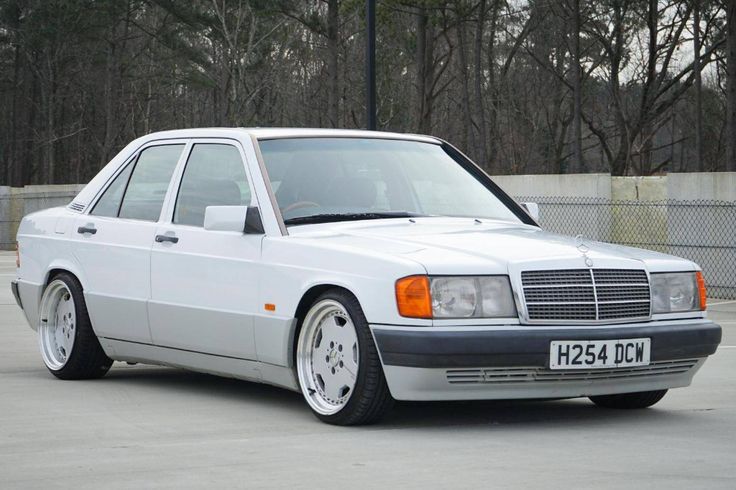 a white mercedes benz parked in a parking lot