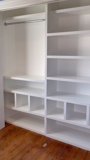 an empty room with white shelving and wood floors