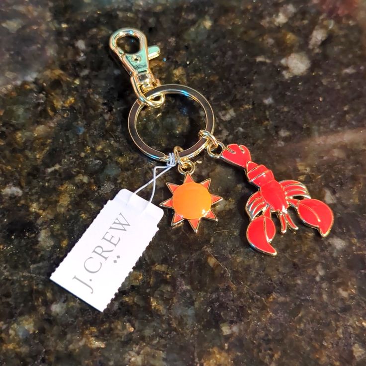 a keychain with a lobster and starfish on it sitting on a granite counter