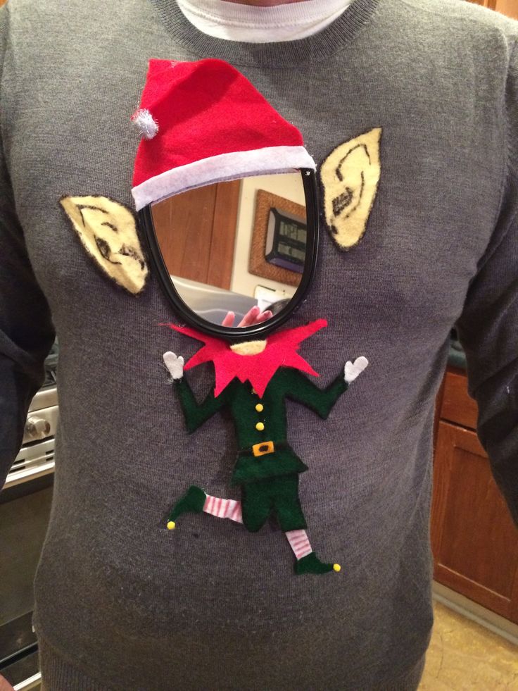 a man wearing a christmas sweater with an elf hat