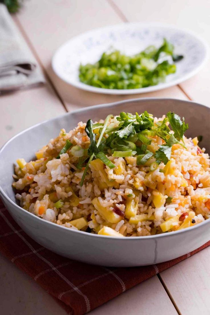 a bowl filled with rice and vegetables on top of a table