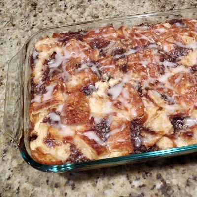 a casserole dish with cinnamon rolls and icing in it on a counter