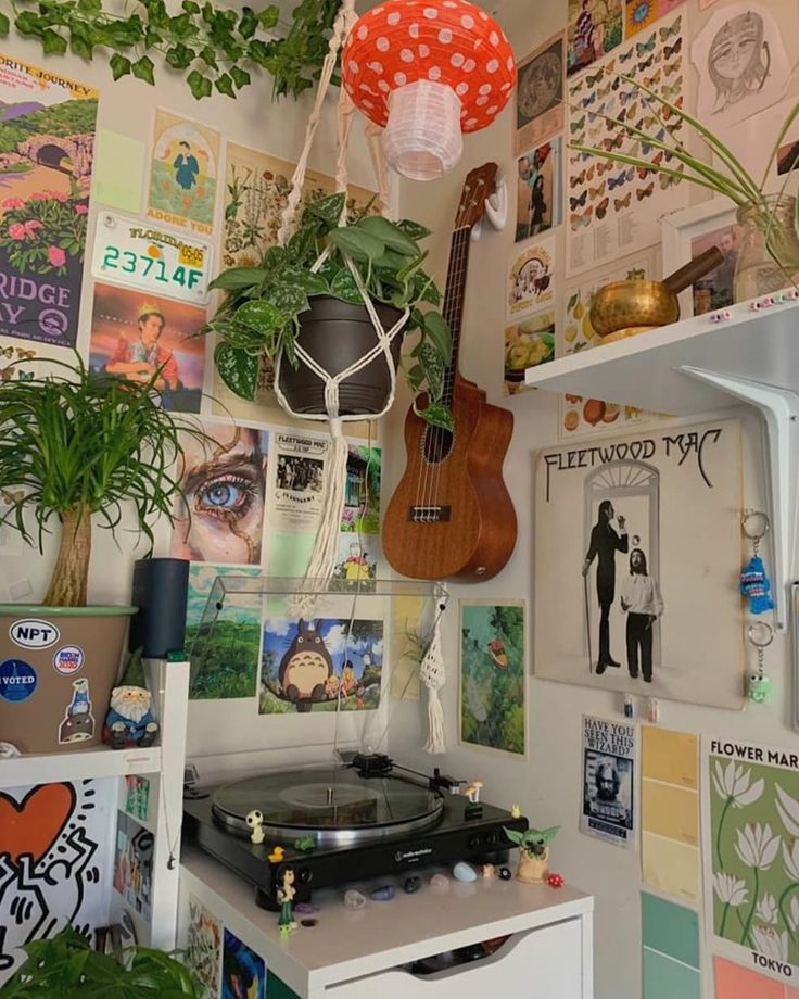 a room filled with lots of plants and pictures on the wall next to a record player