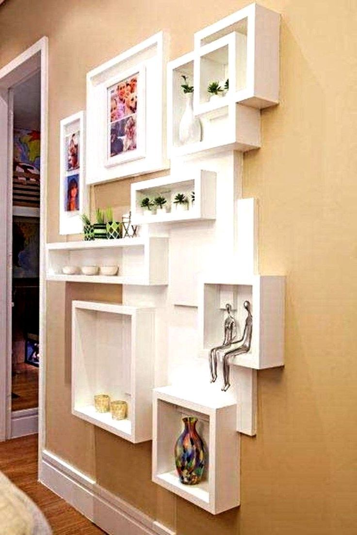 the shelves are all white and have pictures on them, as well as vases