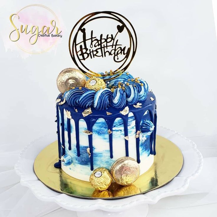 a birthday cake with blue icing and gold decorations