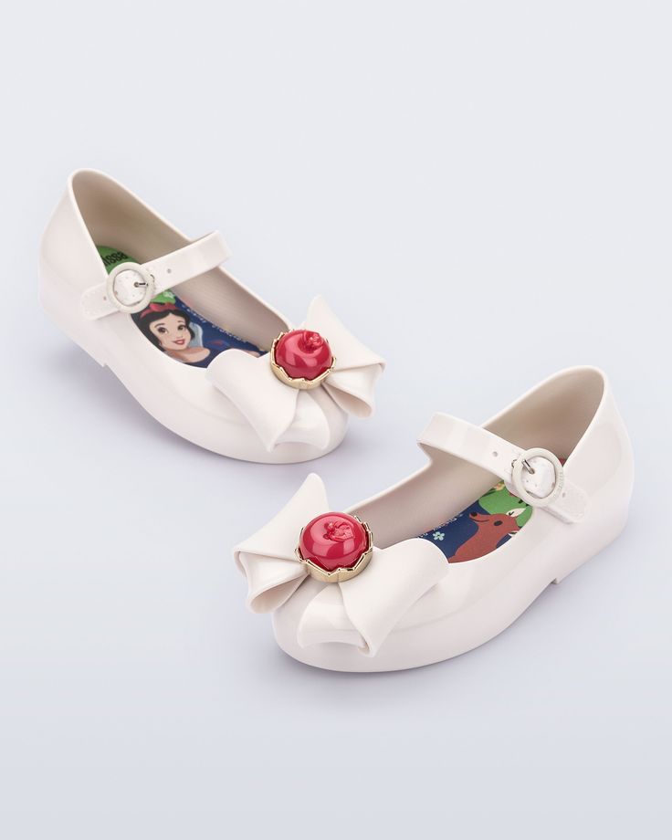 The fairest of them all, meet the Mini Melissa Sweet Love + Snow White ballerina flat. This sweet Disney collaboration brings the world of Snow White to life with a classic ballet-style shoe complete with an elaborate apple bow appliqué, a fairy tale scene on the comfy insole and varying colors to choose from. White Ballerina Flats, Melissa Sweet, The Fairest Of Them All, Fairest Of Them All, Ballet Fashion, Mini Melissa, The Comfy, A Fairy Tale, Shoes Baby